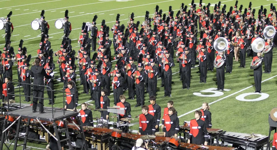 La Marching Band della Collège Churchill High School suona sul campo da football davanti agli spettatori.