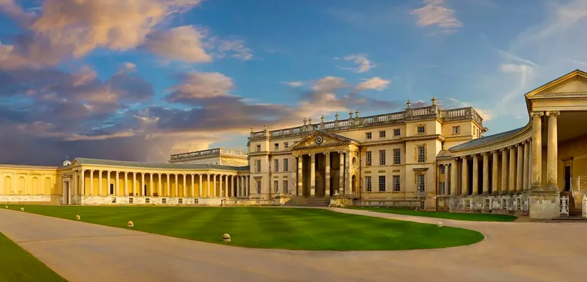 Il maestoso edificio con la facciata a colonne nel campus del Carfax College si erge sotto un cielo nuvoloso.