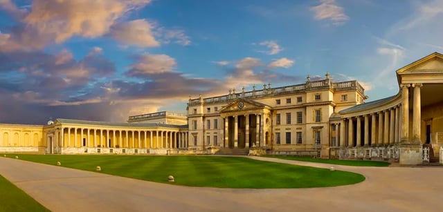 Il maestoso edificio con la facciata a colonne nel campus del Carfax College si erge sotto un cielo nuvoloso.