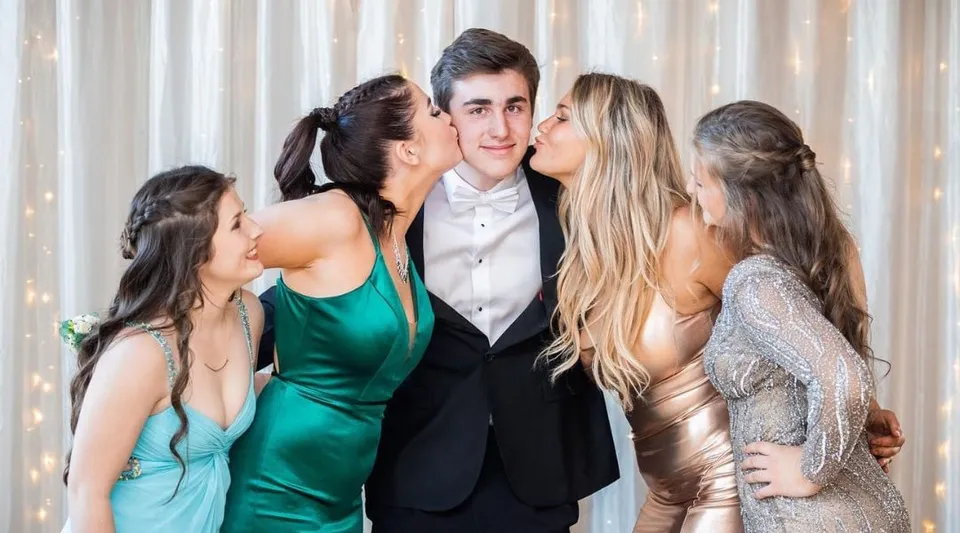 Un gruppo di studenti della Tilton School posa a un evento formale con un ragazzo al centro.