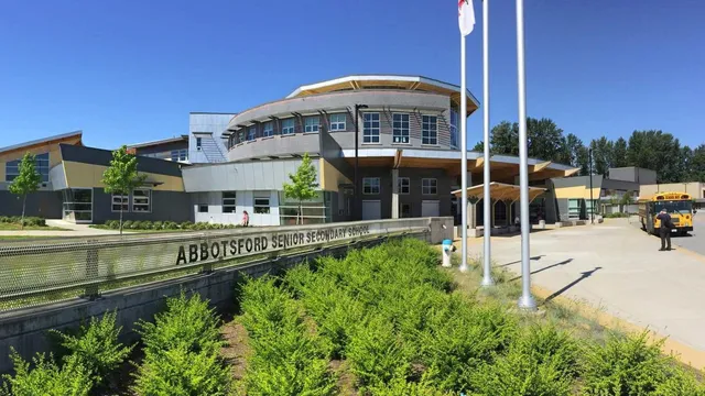 L'edificio moderno a più piani con un tetto curvo della Abbotsford Senior Secondary School si trova in un ambiente immerso nel verde.