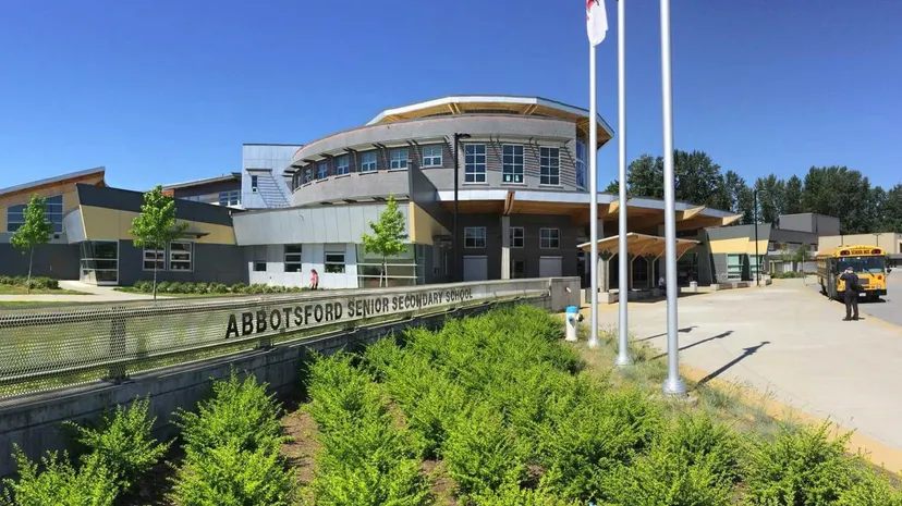 L'edificio moderno a più piani con un tetto curvo della Abbotsford Senior Secondary School si trova in un ambiente immerso nel verde.