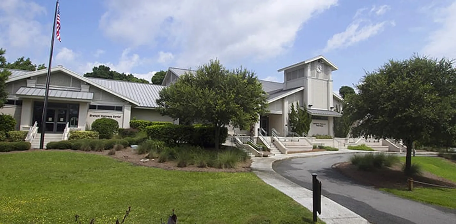 L'edificio ben tenuto della Hilton Head Preparatory School con tetto in metallo e alto camino si trova su un prato accanto a un sentiero pavimentato.