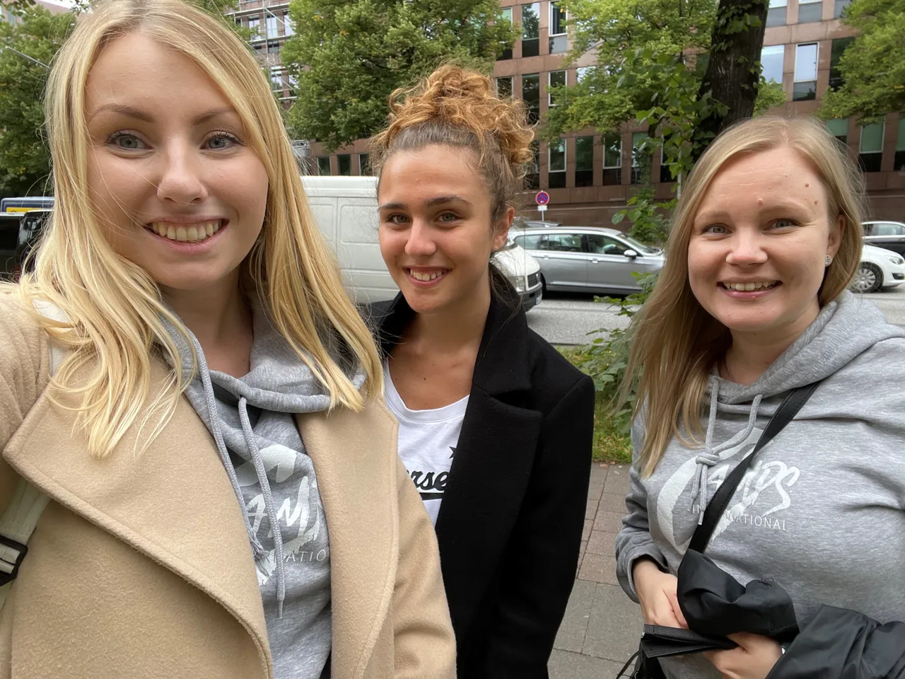Tre ragazze sorridenti in una strada cittadina durante un soggiorno all'estero