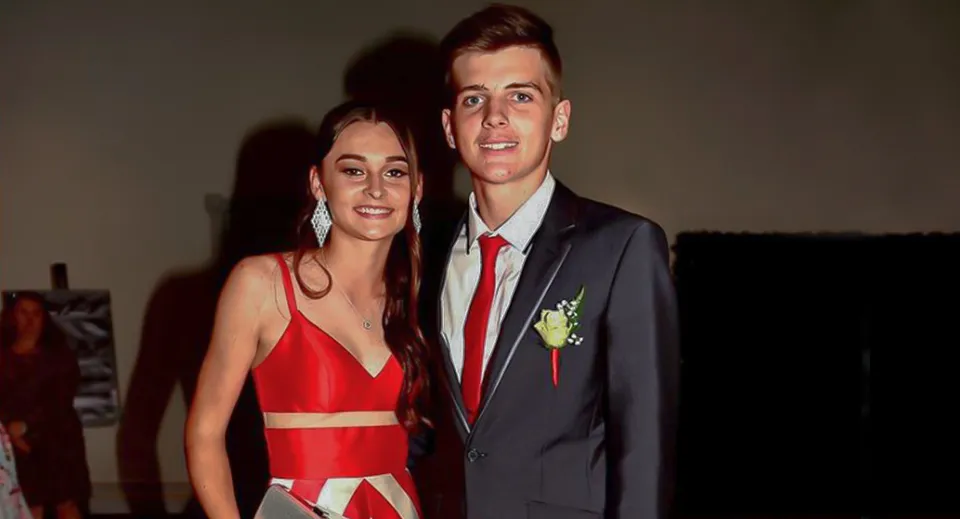 Una giovane coppia in abito formale a un evento nel campus della William Ross State High School.