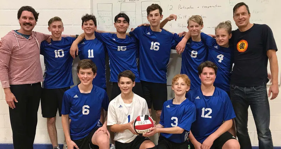 Un gruppo di studenti della Selkirk Secondary School si mette in posa come squadra di pallavolo nella palestra.