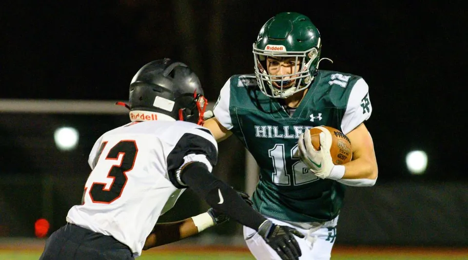 Due giocatori di football in azione sul campo nel terreno della Tower Hill School.