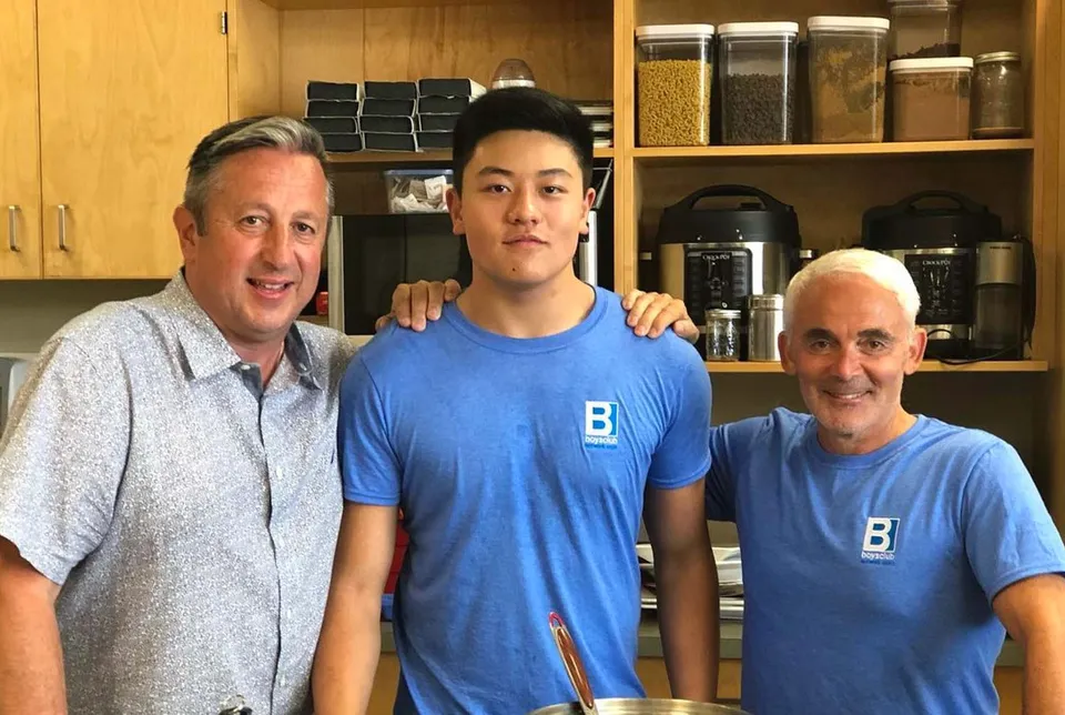 Tre persone si trovano insieme in una cucina o dispensa della Sutherland Secondary School.