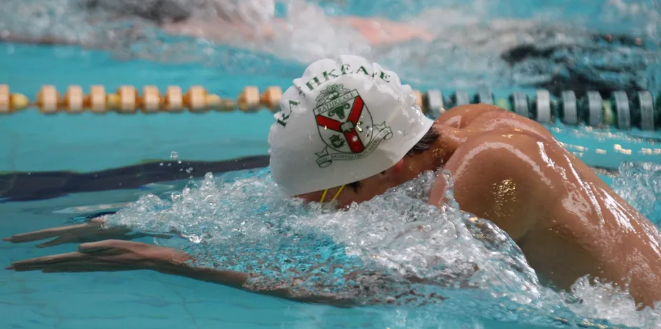 Un nuotatore con cuffia si immerge nella piscina del Rathkeale College mentre l'acqua schizza.
