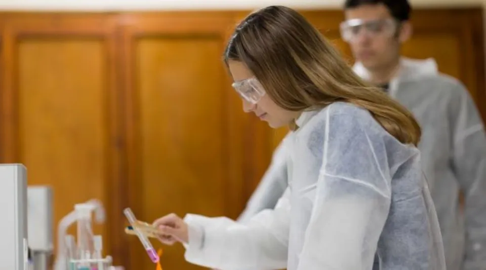 Una donna in una stanza con pareti in legno tiene in mano un dispositivo mobile nel campus del Colegio Esclavas.