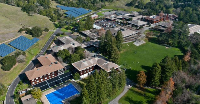 Ein malerisches alpines Dorf mit traditionellen Gebäuden und Solarpanels in der Nähe der San Domenico School.