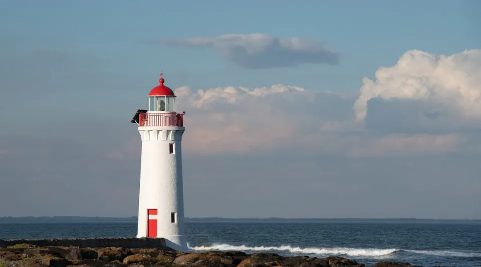 Un faro bianco con la cima rossa si trova sulla costa rocciosa all'interno del terreno della Leeming Senior High School.