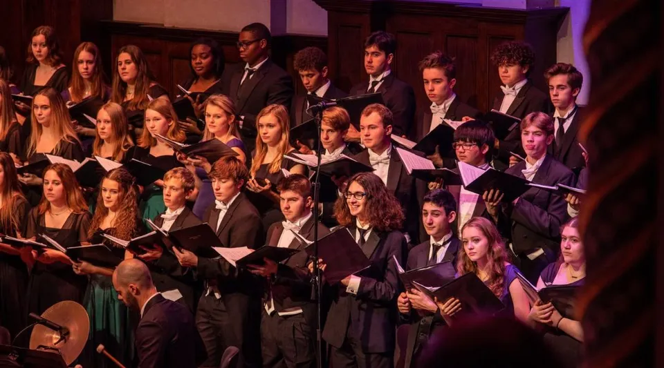 Studenti della Lake Orion High School mettono in scena un'esibizione musicale sul palco in abiti formali.