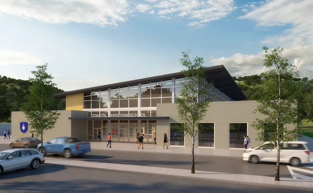 Das moderne mehrstöckige Gebäude der Coastal Christian School mit Glasfassade steht in urbaner Umgebung mit Bäumen und parkenden Fahrzeugen.
