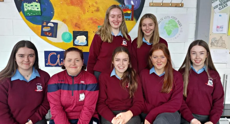 Un gruppo di studentesse della St. Brendan’s Community School davanti a un murale colorato.