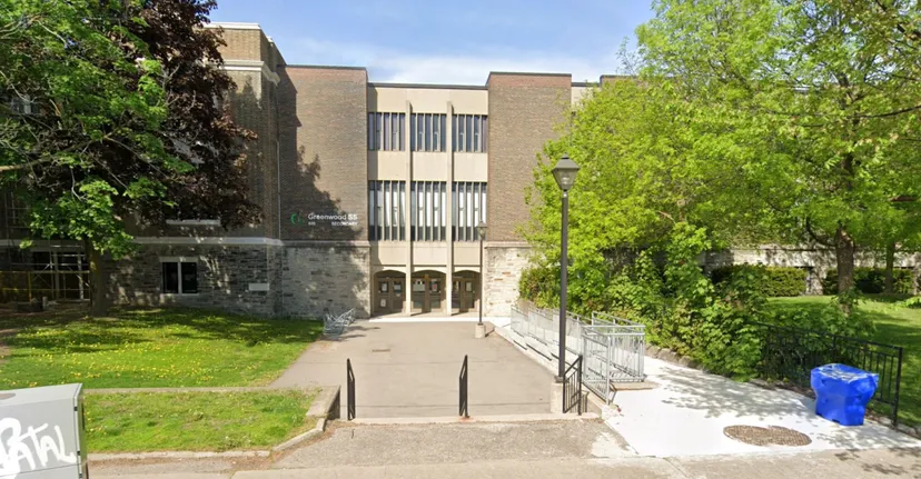 L'edificio moderno a più piani della Greenwood Secondary School è circondato da aree verdi con un viale pavimentato verso l'ingresso.