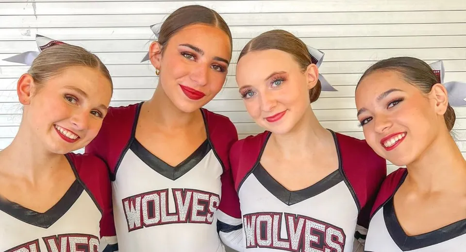 Quattro giovani atlete posano in maglie rosse e bianche con la scritta Wolves nello Scottsdale Unified School District.