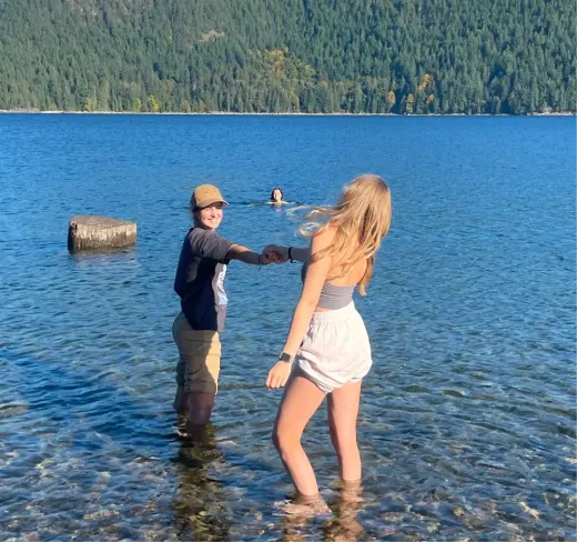 Zwei Mädchen planschen im Wasser eines Bergsees in Kanada