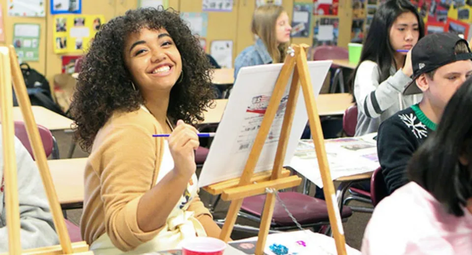 Una studentessa dipinge su un cavalletto durante la lezione d'arte del Chaffey Joint Union High School District.