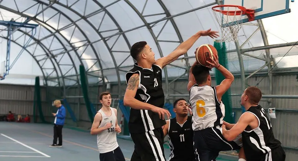 Studenti giocano a basket nella palestra dell'East Sussex College Eastbourne.