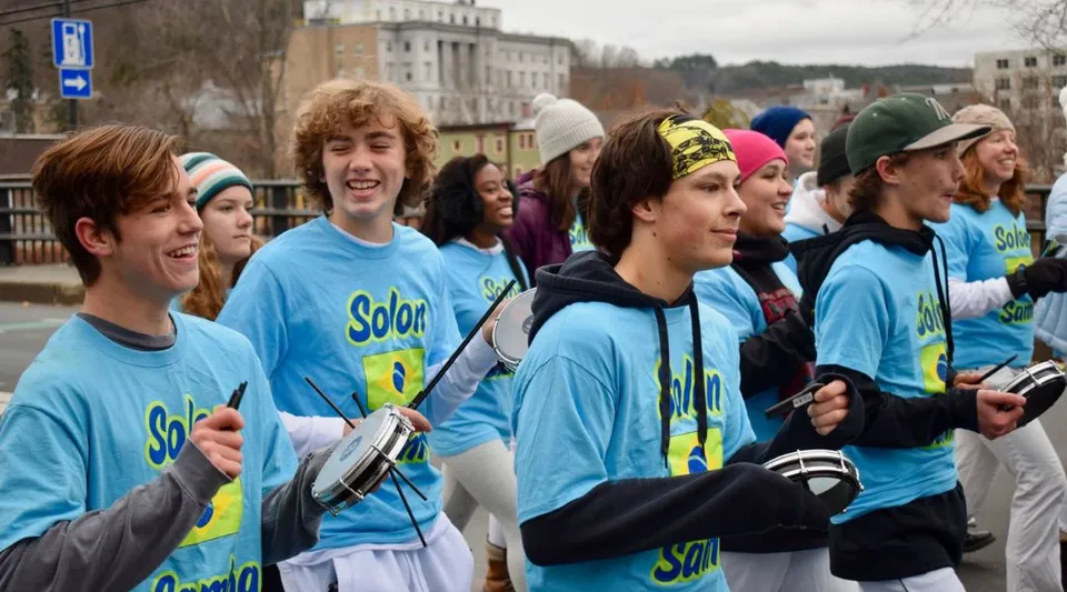 Studenti del Montpelier Roxbury Public School District indossano maglie blu uniformi in un ambiente urbano.