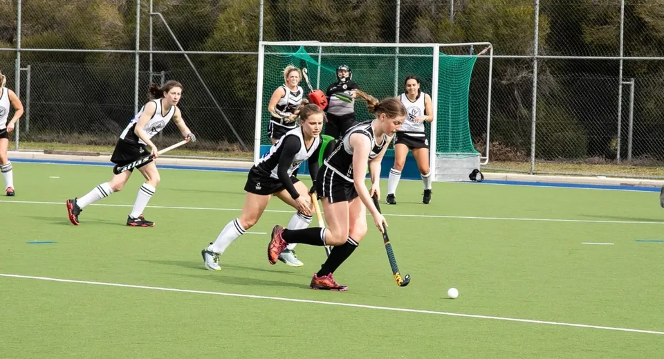 Studenti della Rockford Manor School giocano una partita di hockey su prato sul campo in erba sintetica.