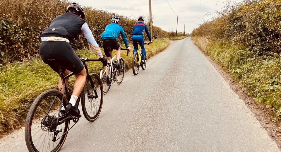 Un gruppo di studenti della Milton Abbey School percorre in bicicletta un sentiero lastricato attraverso il paesaggio.