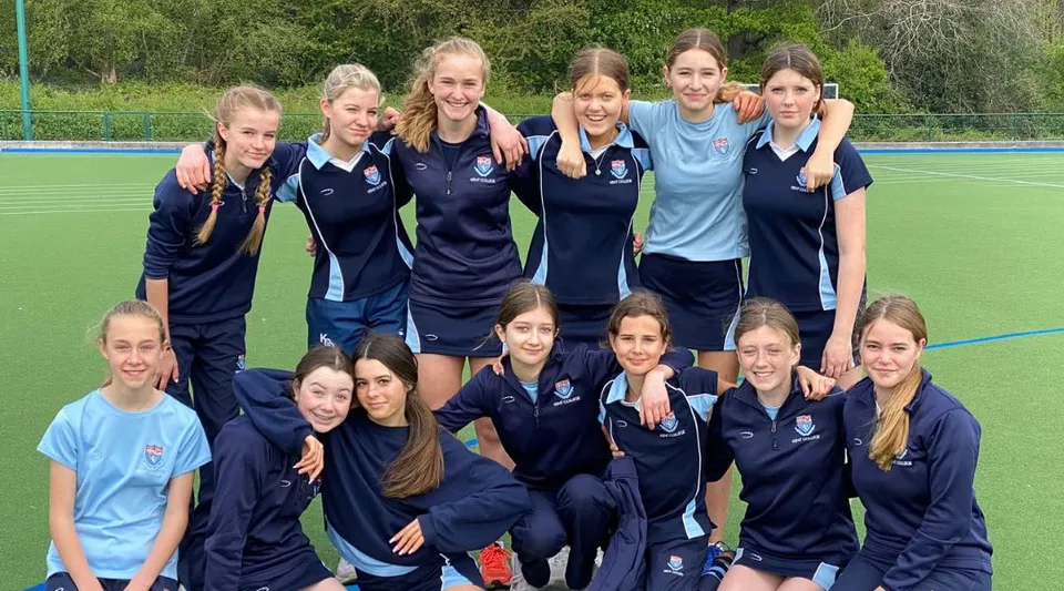 Un gruppo di giovani atlete si raduna sul campo sportivo del Kent College Pembury.