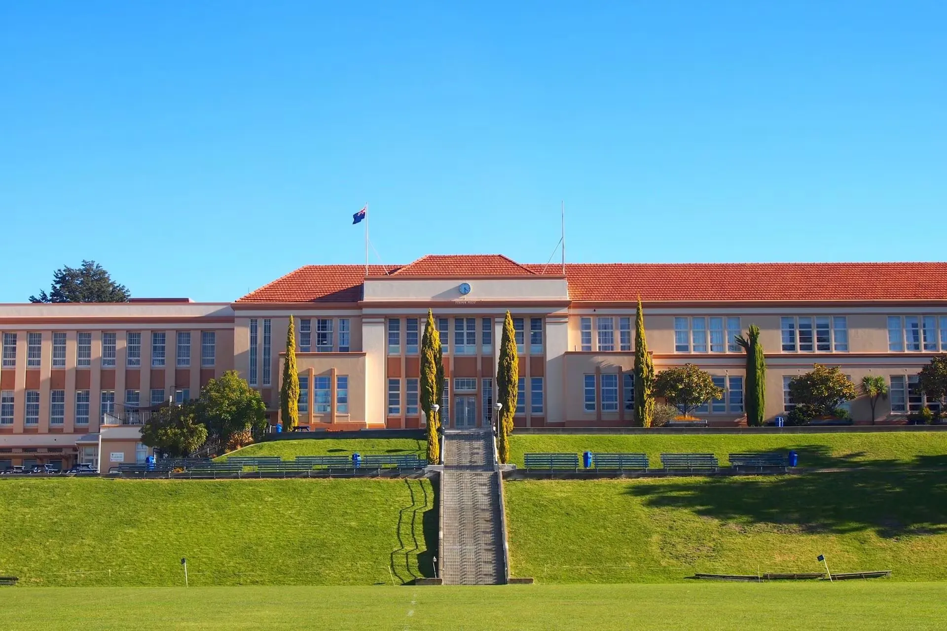 L'edificio a più piani con tetto in tegole rosse si trova nel campus del Nelson College for Boys in una giornata di sole.