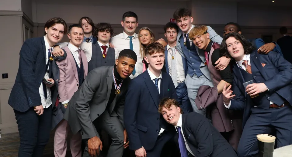 Un gruppo di giovani uomini in abito formale durante una festa nel campus del Portlaoise College.