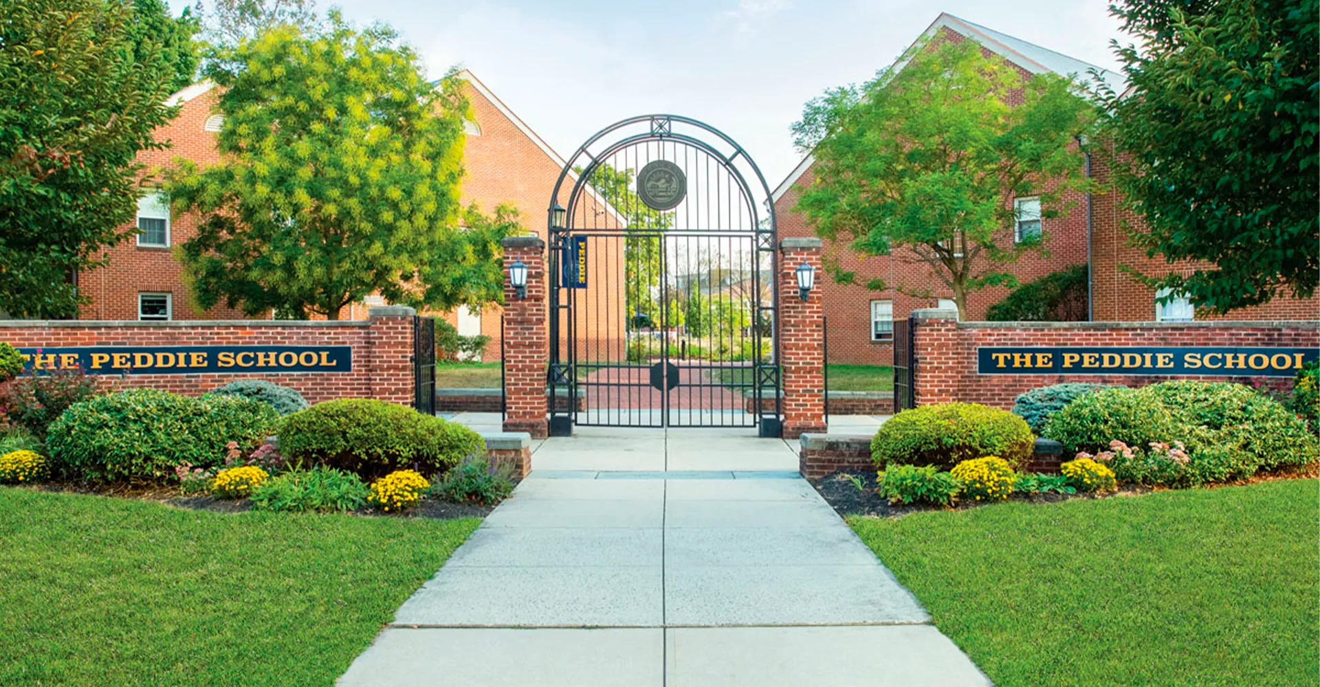 L'ingresso della The Peddie School con un arco in mattoni e vista sul campus ben tenuto con aree verdi ed edifici.