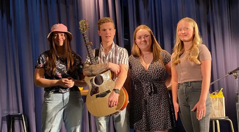 Quattro persone, tra cui studenti e studentesse, stanno come musicisti sul palco della Polyvalente Alexandre-J.-Savoie.