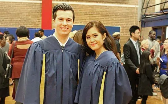 Dos graduados con togas están juntos en la ceremonia de graduación del George Harvey Collegiate Institute.