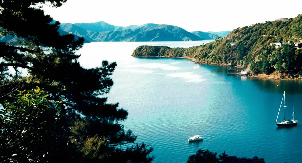 Un lago tranquillo con una piccola barca e boschi verdi sullo sfondo nel campus della ACG Strathallan.