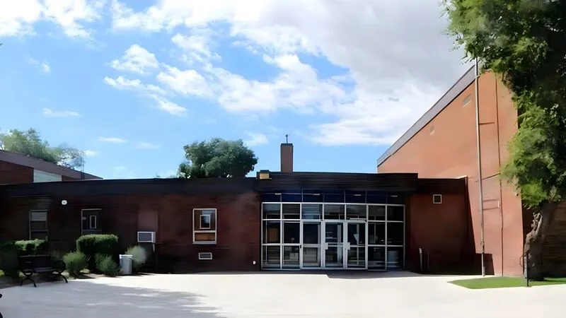 Schulgebäude aus dunklem Backstein mit verglastem Haupteingang
