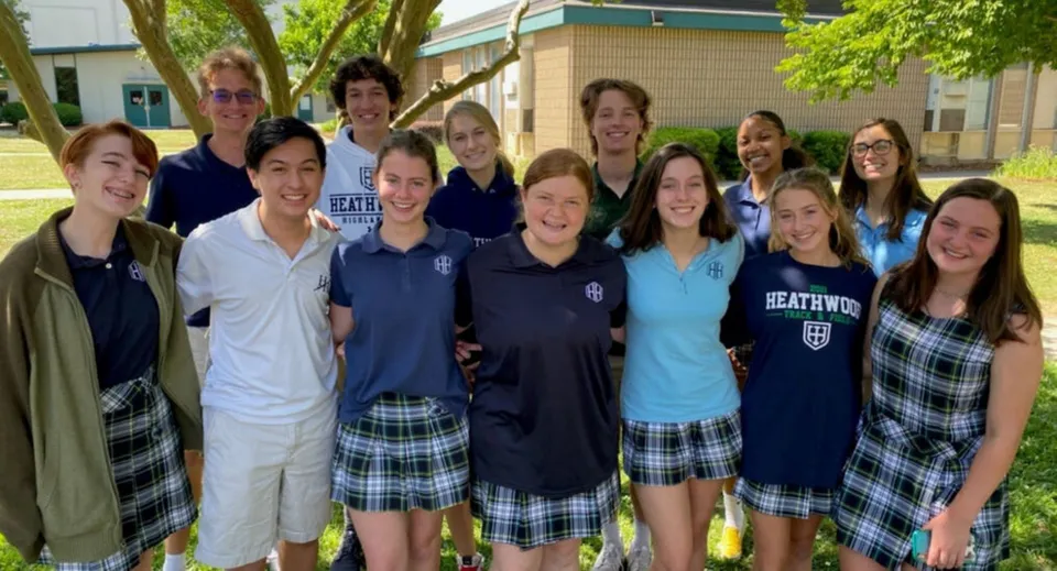 Un gruppo di studentesse sorridenti si trova insieme nel campus della Heathwood Hall Episcopal School.