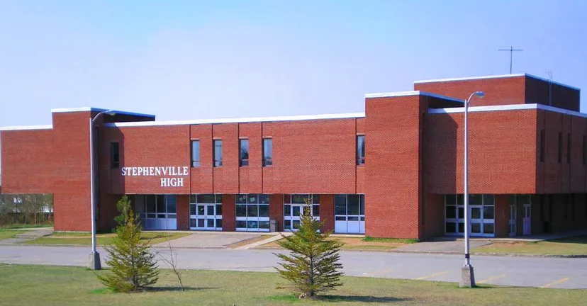 L'edificio in mattoni rossi della Stephenville High School è circondato da alberi e si trova su un'area pavimentata.