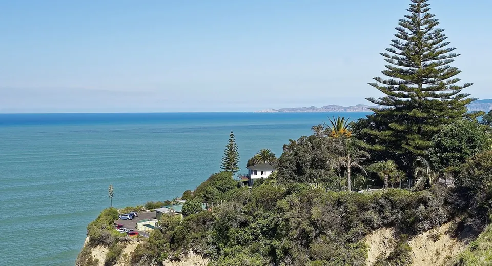 Pendio verde con vista sul vasto mare e sulle montagne sullo sfondo nel campus del Lynfield College.
