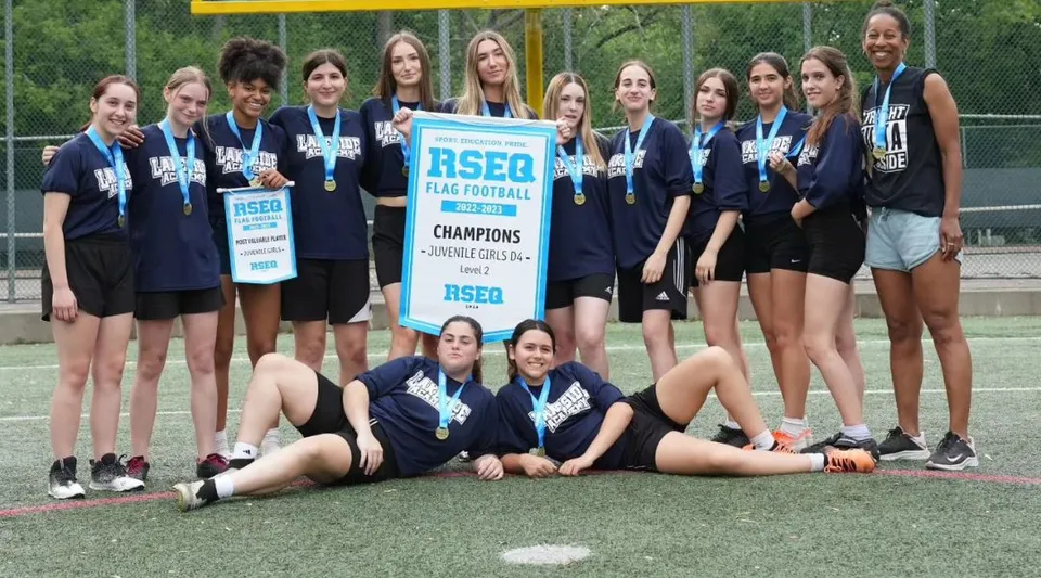Un gruppo di studentesse della Lakeside Academy festeggia sul campo sportivo la vittoria al torneo di flag football con una coppa.