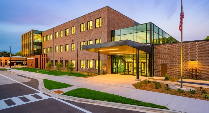 L'edificio moderno a più piani della Notre Dame de la Baie Academy, con grandi vetrate e un ingresso accogliente, è circondato da un'area esterna ben curata.