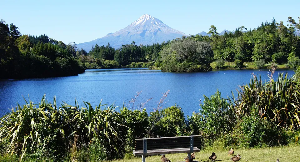 Un lago tranquillo davanti a una cima innevata nei terreni del Francis Douglas Memorial College.