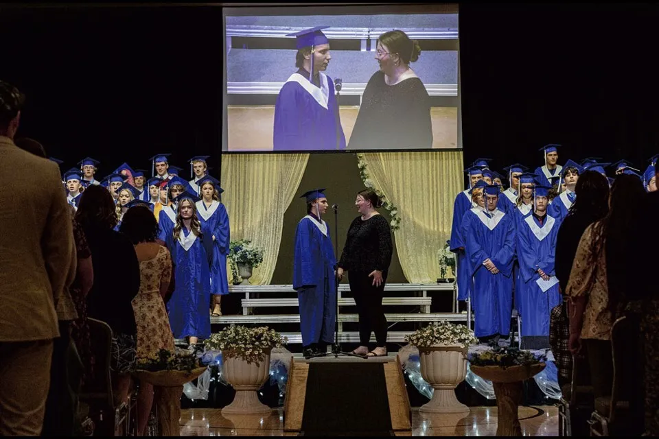 Gli studenti della College Heights Secondary School sono sul palco in toga blu durante la cerimonia di diploma.