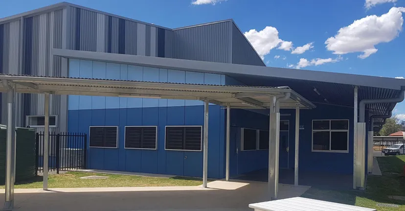 L'edificio moderno della Kingaroy State High School mostra una facciata blu con ingresso coperto e un prato antistante.