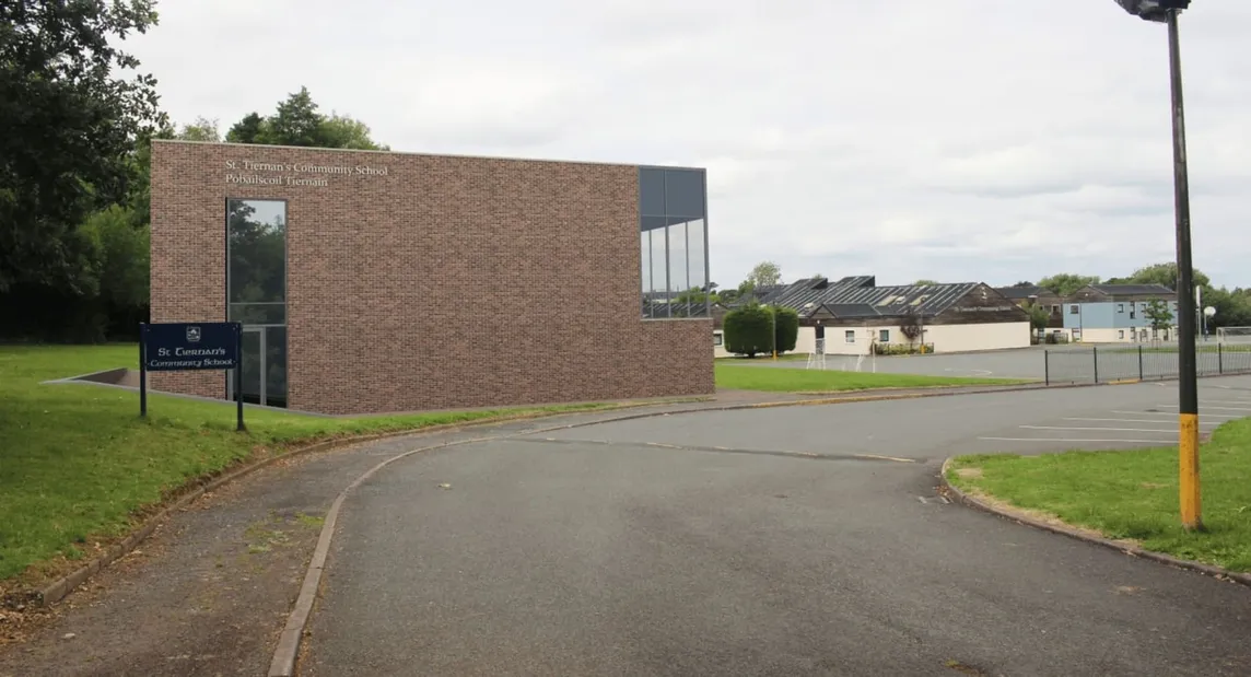 Backsteingebäude einer Schule mit Vorfahrt und Parkplatz, im Hintergrund weitere Gebäude nahe Dublin