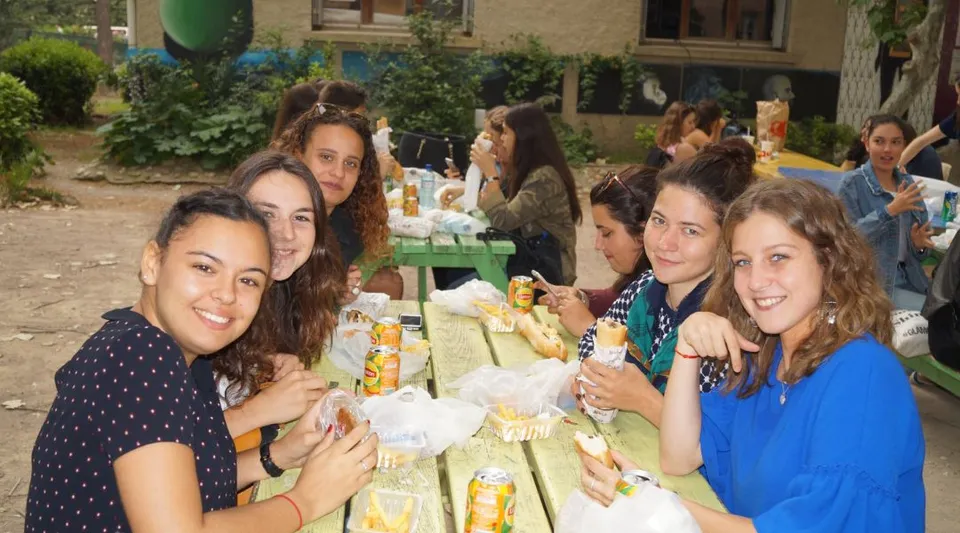 Studentesse del Lycée Notre Dame de Bon Secours si godono un pasto insieme in giardino.