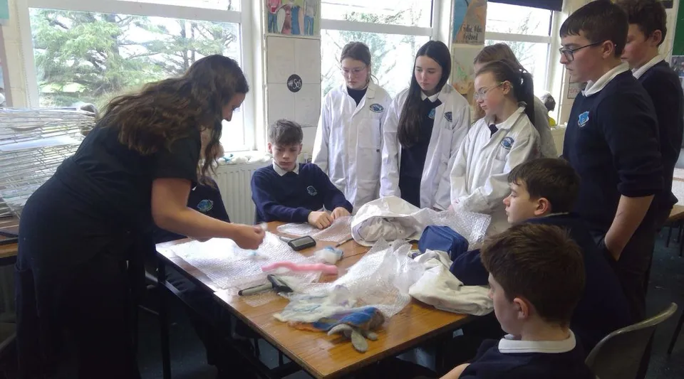 Studenti dell'Iascaigh College esaminano insieme diversi oggetti durante un esperimento.