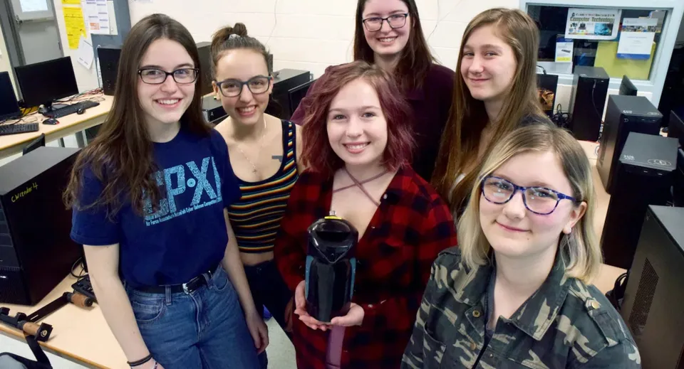 Un gruppo di studentesse della Centre Wellington District High School sorride insieme all'interno di un'aula.