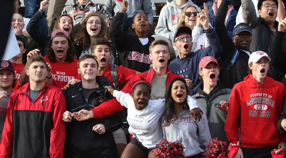 Un grande gruppo di persone festeggia insieme negli spazi della The Lawrenceville School.