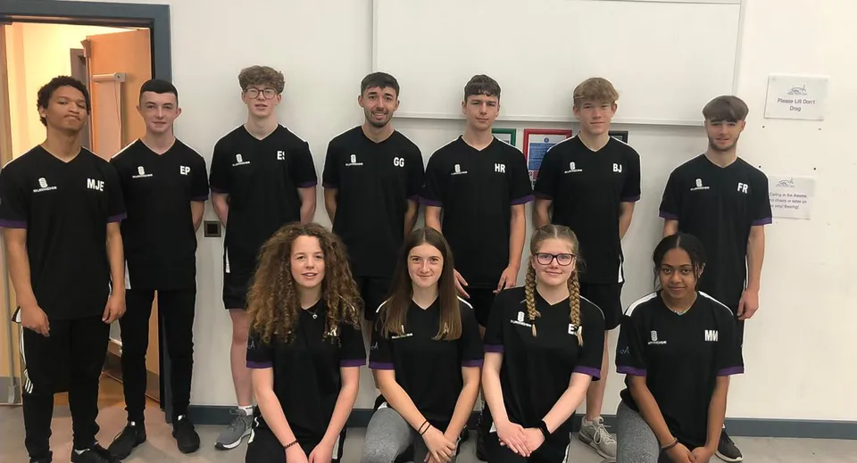 Un gruppo di studenti con magliette nere si trova insieme in un'aula del Salisbury Sixth Form College.