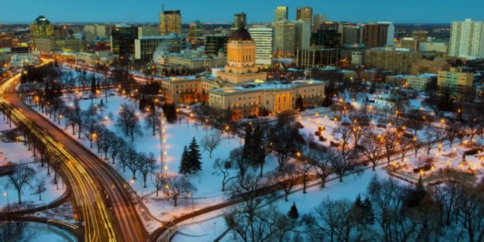 Vista su una città innevata con un grande edificio governativo di notte nel campus della Sisler High School.
